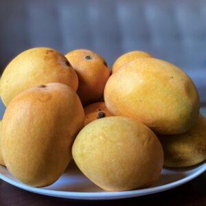 A vibrant display of fresh, ripe mangoes on a white plate, highlighting their juicy and sweet nature.