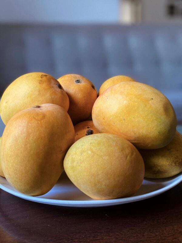 A vibrant display of fresh, ripe mangoes on a white plate, highlighting their juicy and sweet nature.